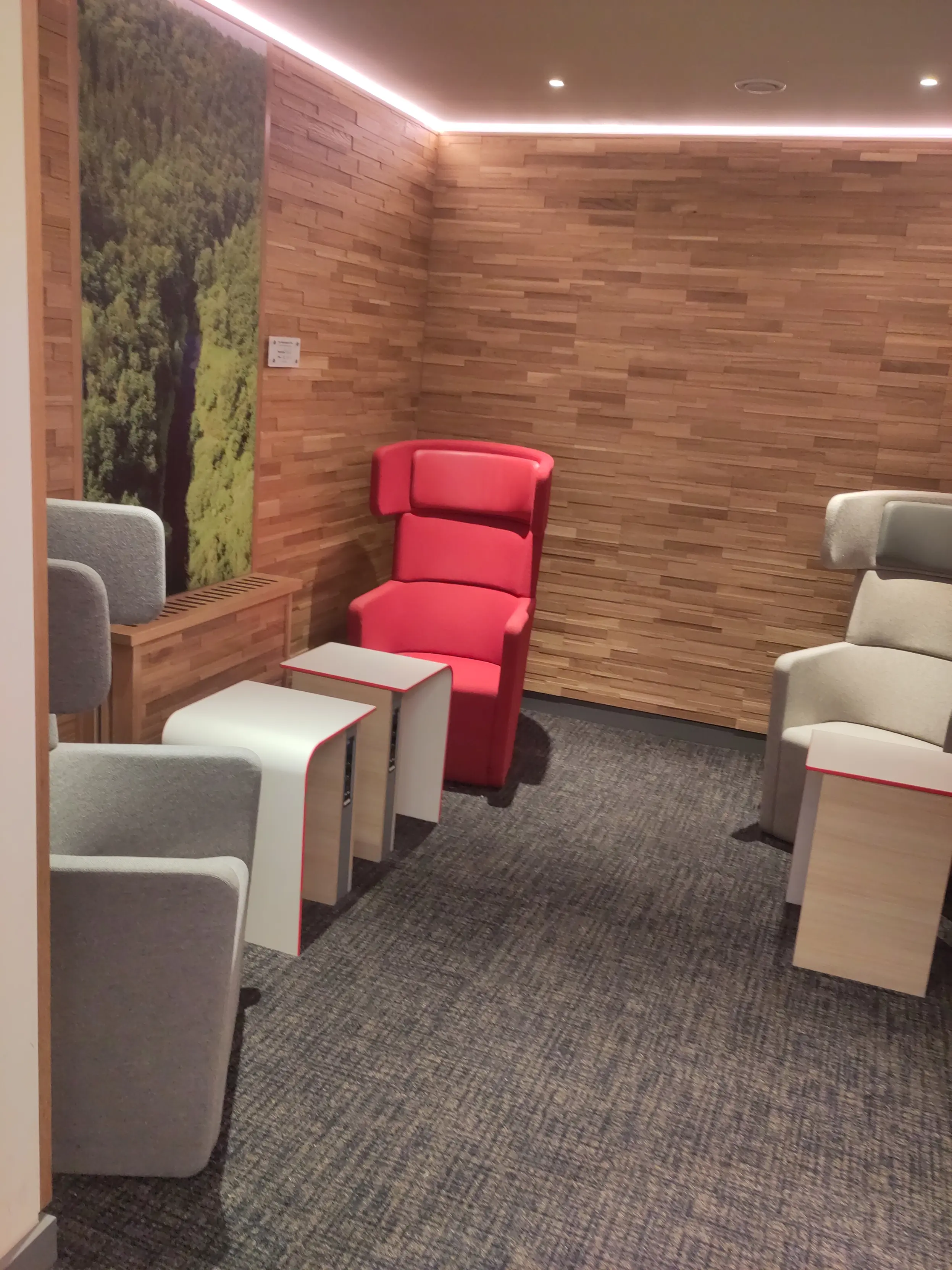 A corner in the dB lounge in Düsseldorf.
It has three chairs each with their own small table.
It looks quite cozy